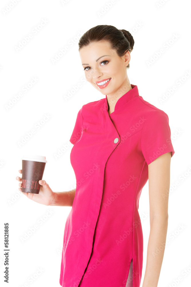 Attractive woman in pink uniform holding a cup. Attractive woman in pink uniform holding a cup.
