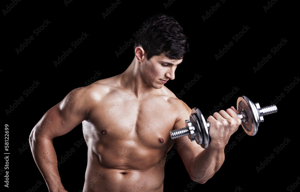 Portrait of a strong man lifting weights against a dark backgrou