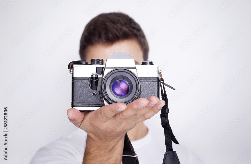 Photographer holding a camera against gray background