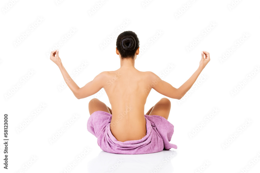 Attractive naked woman sitting in towel.Back view. Attractive naked woman sitting in towel.Back view.