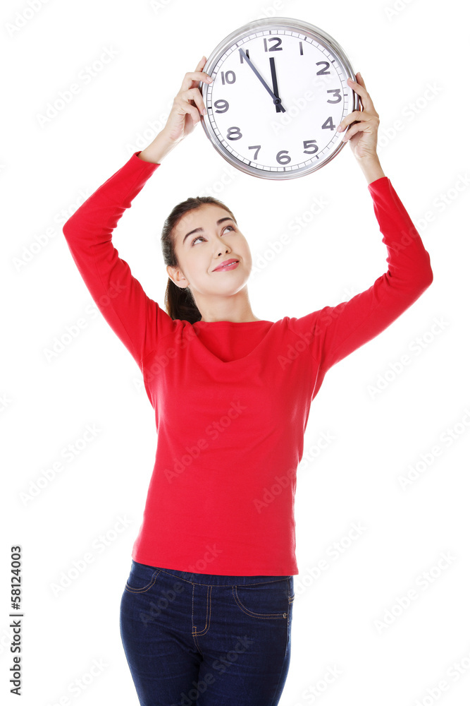 Obraz premium Attractive young woman holding a clock.