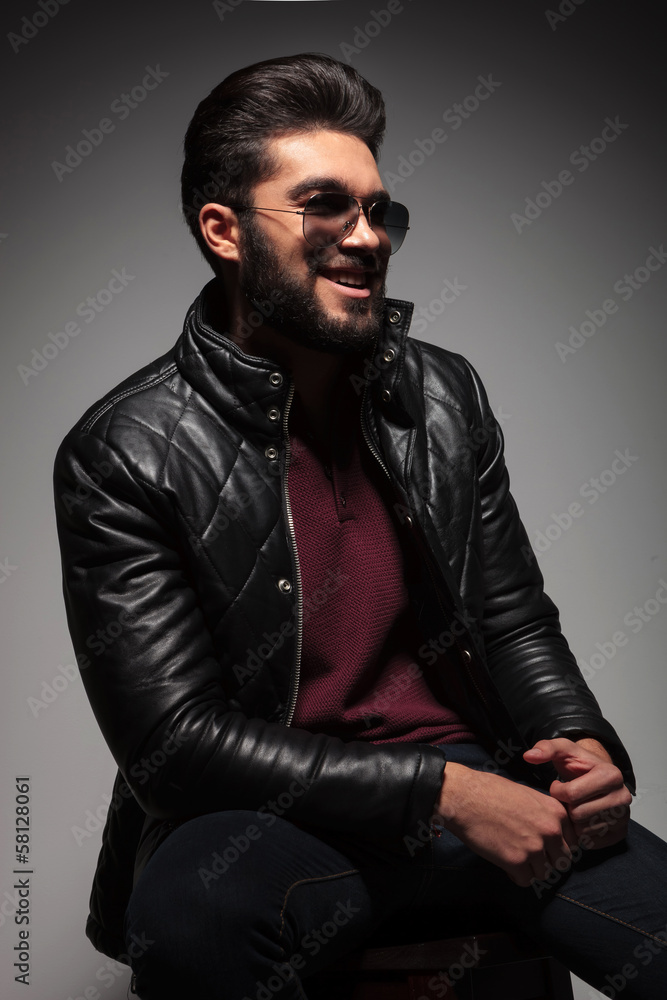 young fashion man with long beard laughing while looking away young fashion man with long beard laughing while looking away