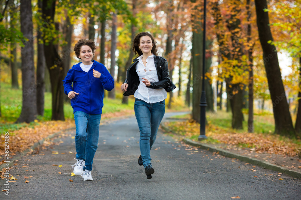 Girl and boy running, jumping in park Girl and boy running, jumping in park