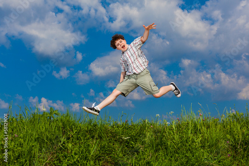 Boy jumping  running against blue sky