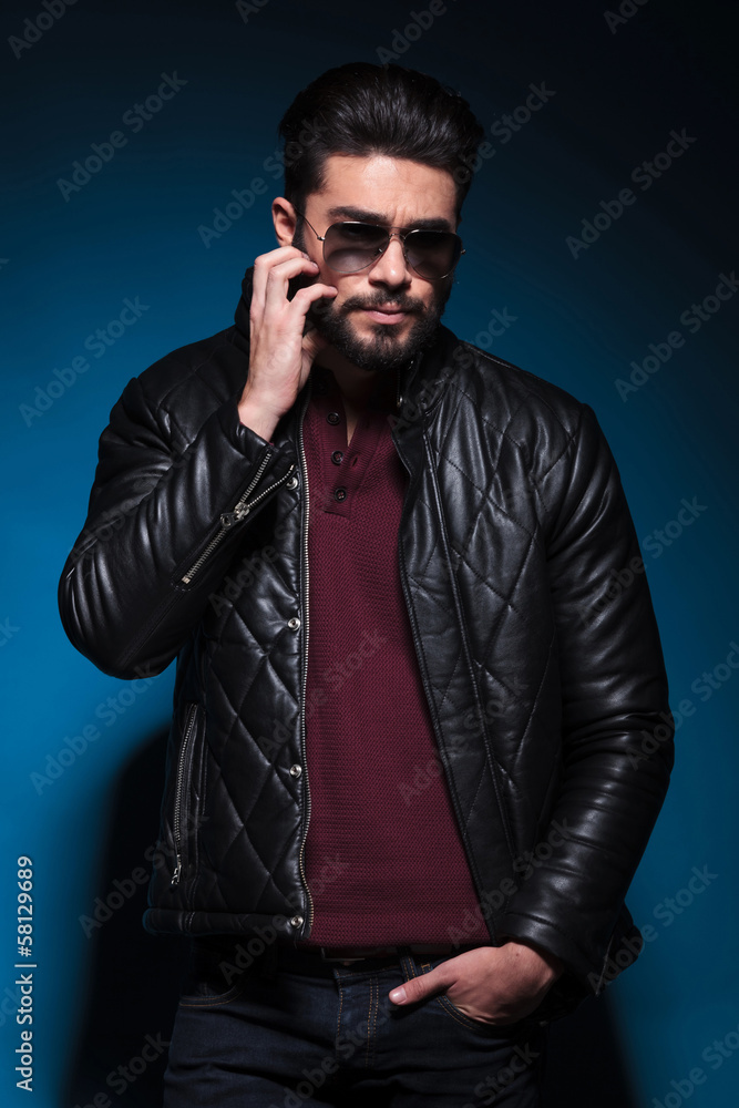 Fototapeta premium man in a leather jacket is scratching his beard