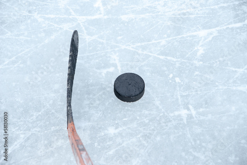 ice hockey stick and puck on ice