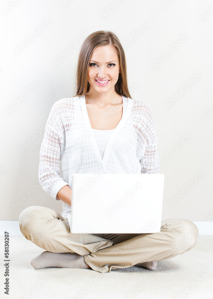 Portrait of pretty happy young woman lying on floor with a lapto Portrait of pretty happy young woman lying on floor with a lapto