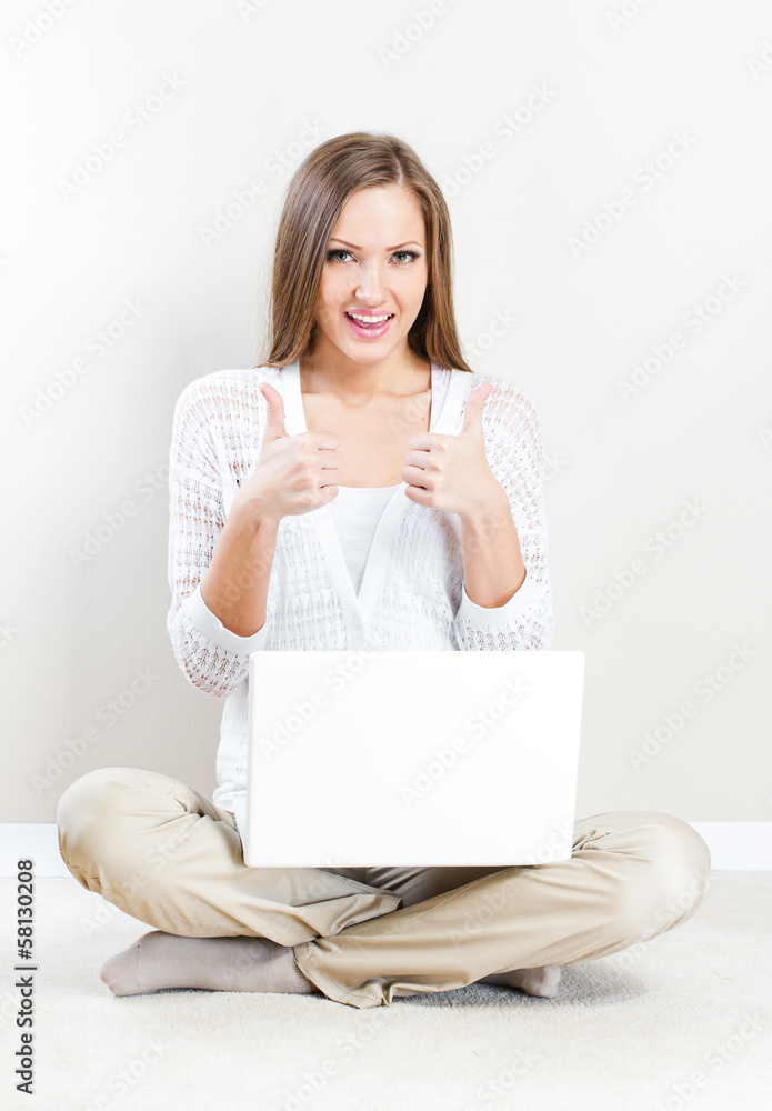 Portrait of pretty happy young woman lying on floor with a lapto Portrait of pretty happy young woman lying on floor with a lapto