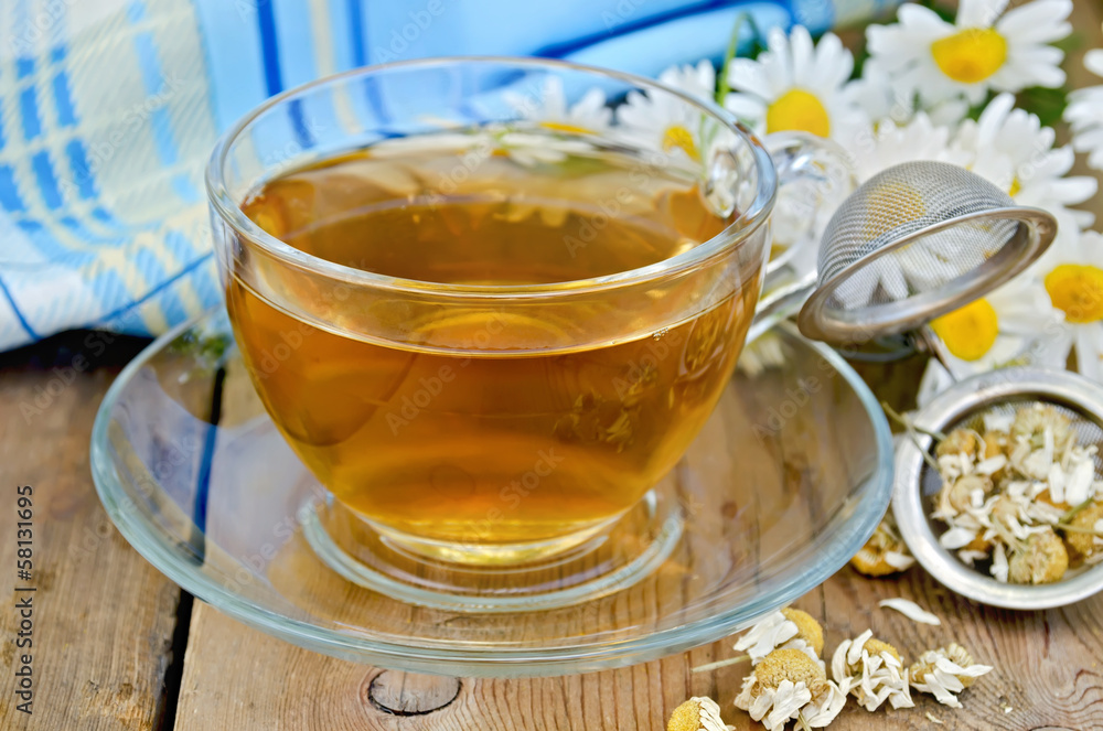 Herbal chamomile tea dry in a strainer with a glass cup Herbal chamomile tea dry in a strainer with a glass cup