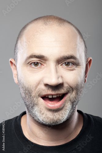 portrait of ironical smiling man isolated on gray background