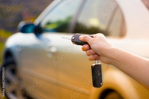 women's hand presses on the remote control car alarm