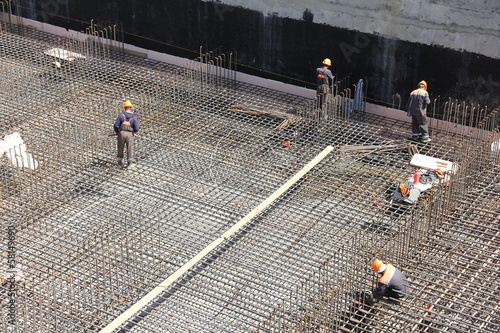 Foto workers make reinforcement for concrete foundation
