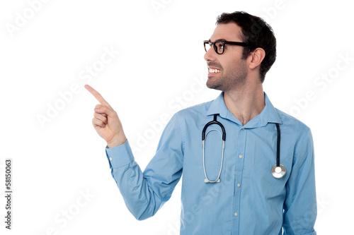 Young doctor pointing copy space area