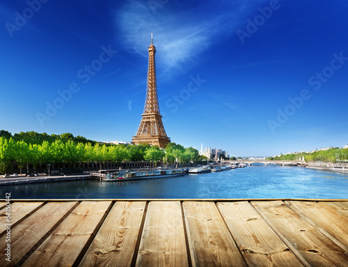 background with wooden deck table and Eiffel tower in Paris © Iakov Kalinin