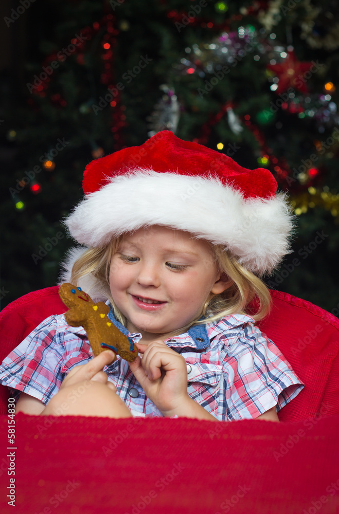 Cute child in santa hat and gingerbread man with copy-space Cute child in santa hat and gingerbread man with copy-space