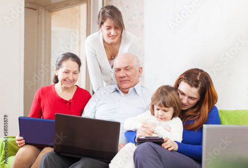 Happy multigeneration family uses few portable computers © JackF