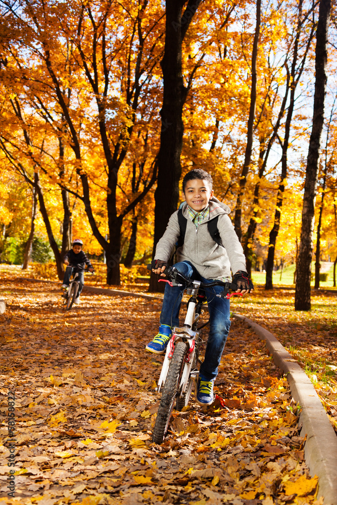Guys riding bike in autumn park