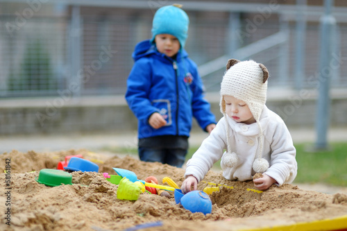 Fotografi Two kids playing in a sandbox