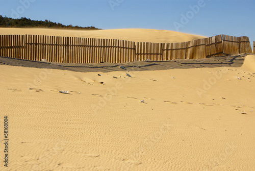 Wooden fences on deserted beach dunes in Tarifa, Spain 