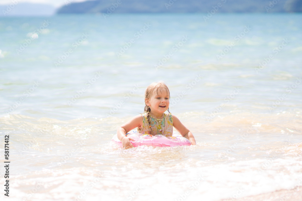 Adorable girl with inflatable ring swim in sea Adorable girl with inflatable ring swim in sea