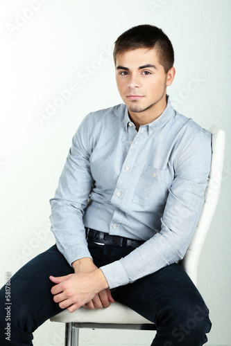 Guy sitting on chair in room