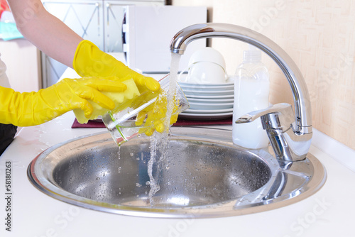 Close up hands of woman washing dishes in kitchen