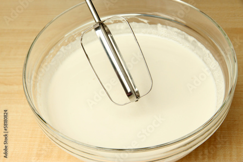 Cooking, whipping eggs with electric whisk in bowl, close up