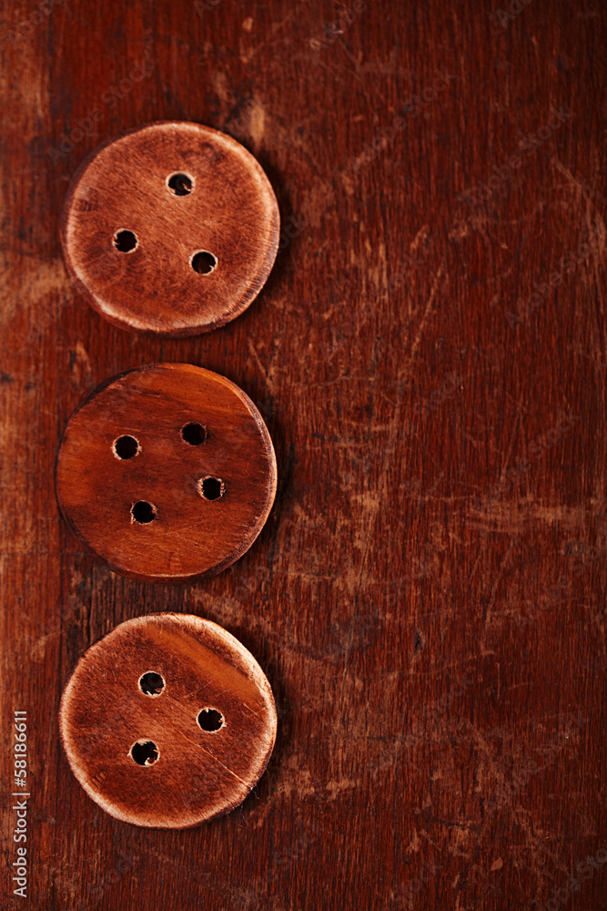 three handmade wooden bottons on old table three handmade wooden bottons on old table