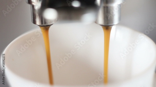 coffee machine pouring espresso in cup extremely close-up