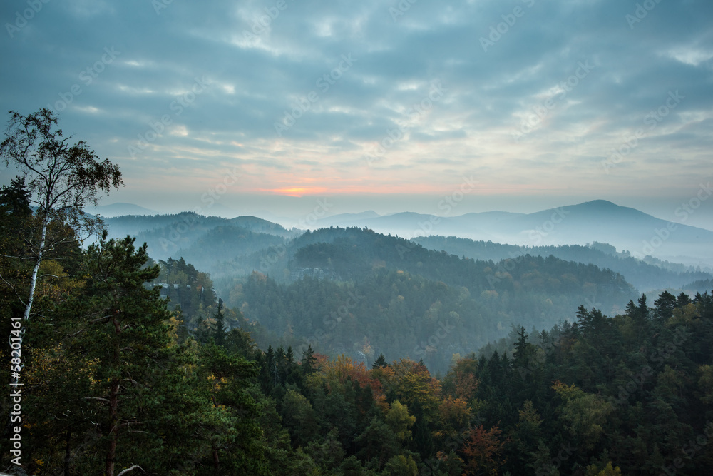 Trees and mountain range against cloudy sky Trees and mountain range against cloudy sky