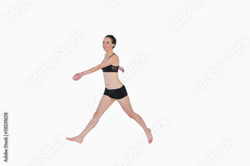 Fototapeta Naklejka Na Ścianę i Meble -  Full length of a sporty young woman walking