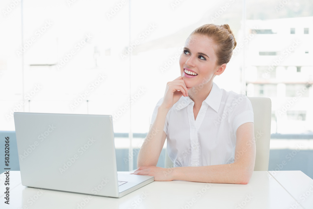 Thoughtful businesswoman using laptop at office desk Thoughtful businesswoman using laptop at office desk