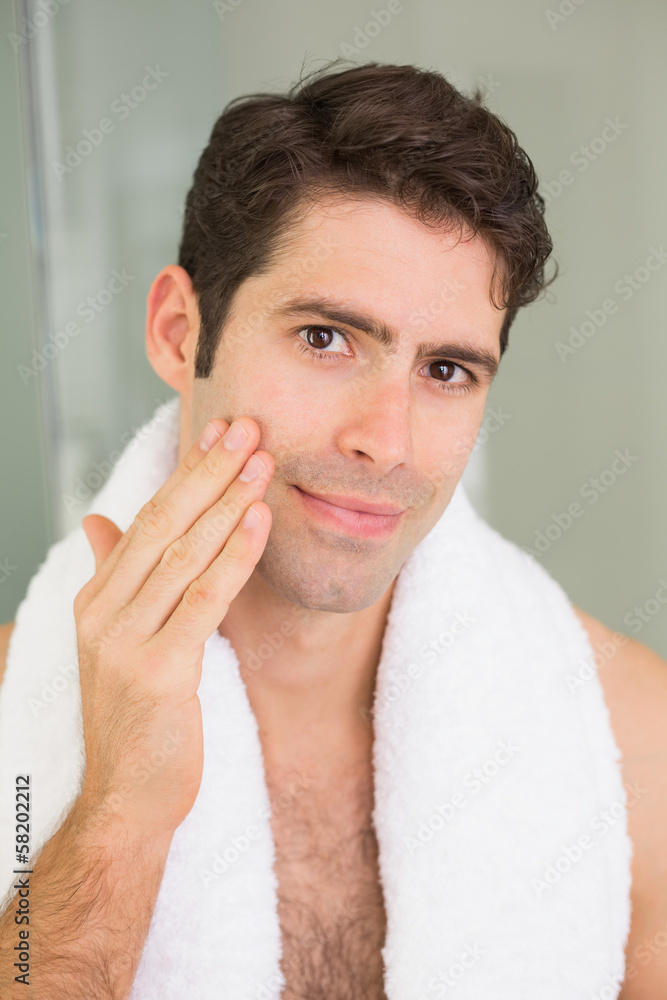 Handsome young man touching his face Handsome young man touching his face
