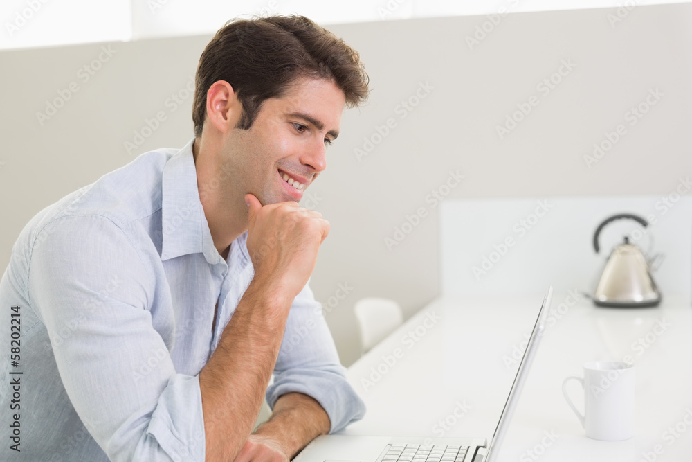 Casual young man using laptop at home Casual young man using laptop at home