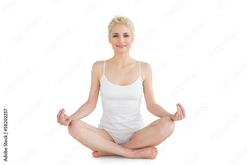 Toned young woman sitting in lotus pose Toned young woman sitting in lotus pose