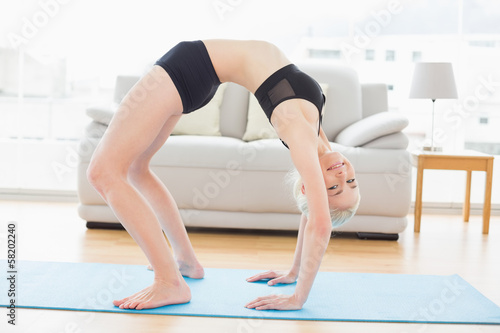 Fit woman doing the wheel pose in fitness studio