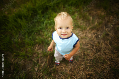 sad little boy portrait in high grass