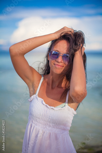 Beautiful young girl standing at beach and looking in camera © travnikovstudio