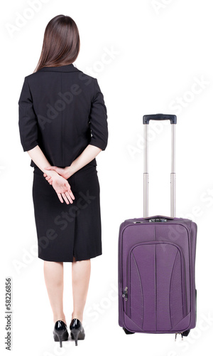 back view of thoughtful business woman traveling with suitcas.