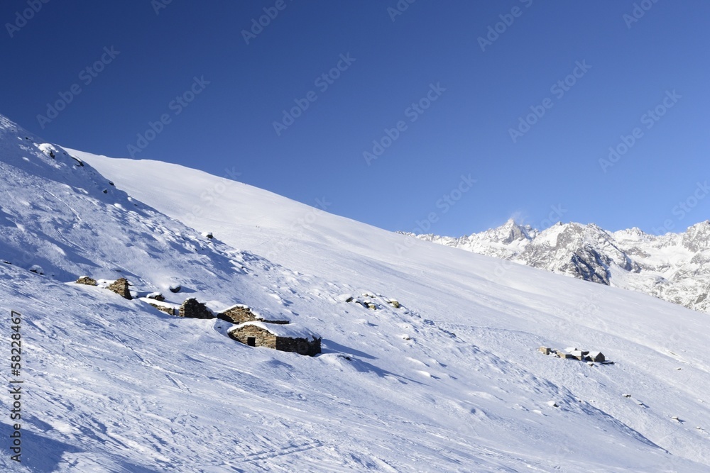 Old pasture huts in scenic winter background
