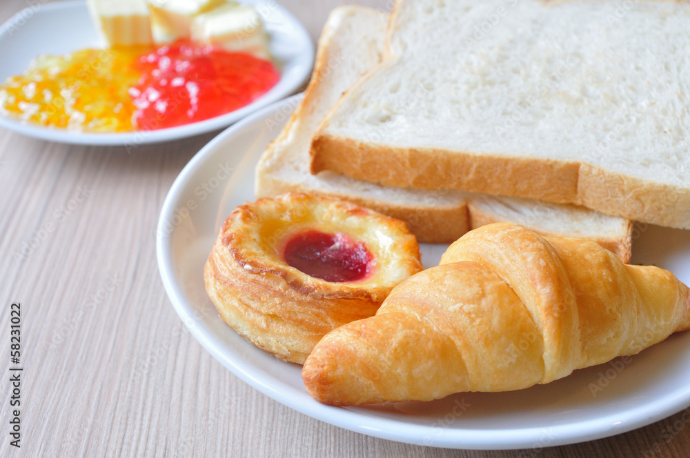 Various breads and Croissants with Jams on breakfast table. Various breads and Croissants with Jams on breakfast table.