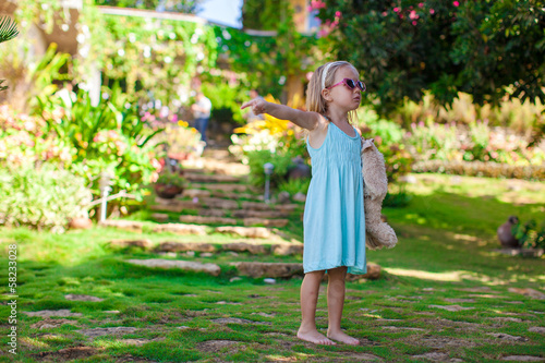 Little girl walking in tropical green hotel