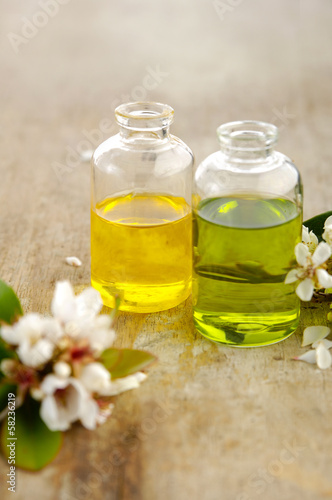 Massage oil with spring flower on old wooden