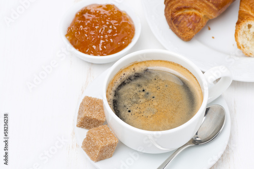 breakfast with black coffee, croissants and orange jam, top view
