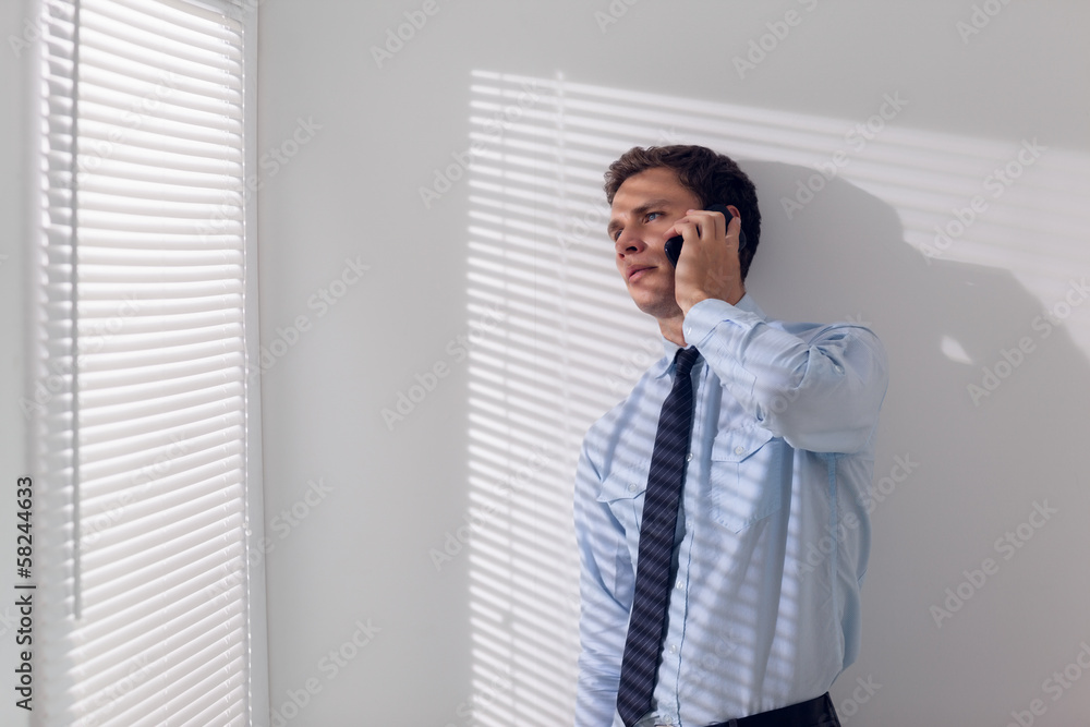 Serious young businessman using mobile phone Serious young businessman using mobile phone