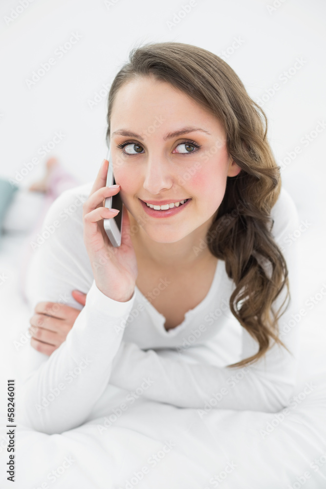 Thoughtful woman using mobile phone in bed Thoughtful woman using mobile phone in bed