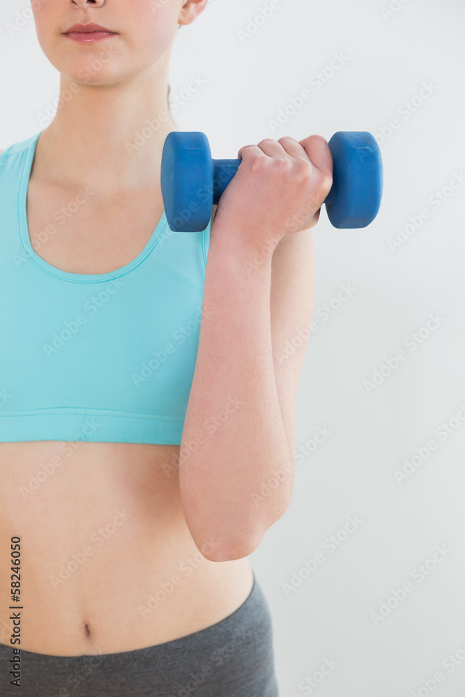 Close up mid section of woman with dumbbell Close up mid section of woman with dumbbell