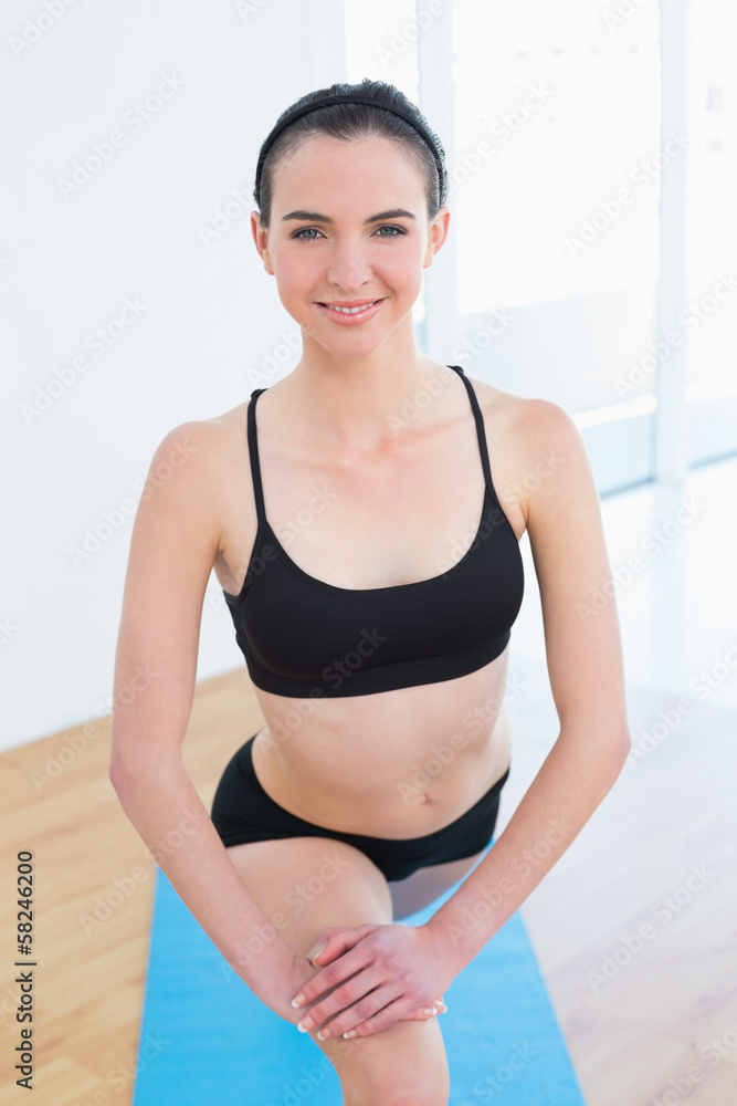 Fit young woman stretching leg in fitness center Fit young woman stretching leg in fitness center