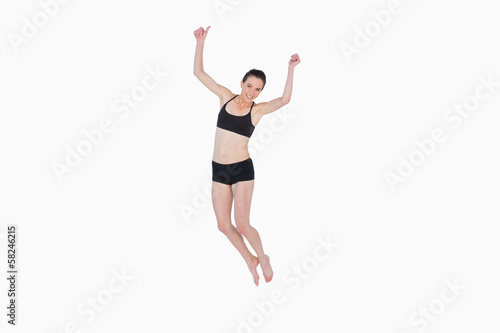 Sporty young woman jumping over white background © lightwavemedia