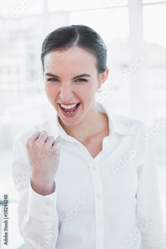 Cheerful businesswoman cheering in office